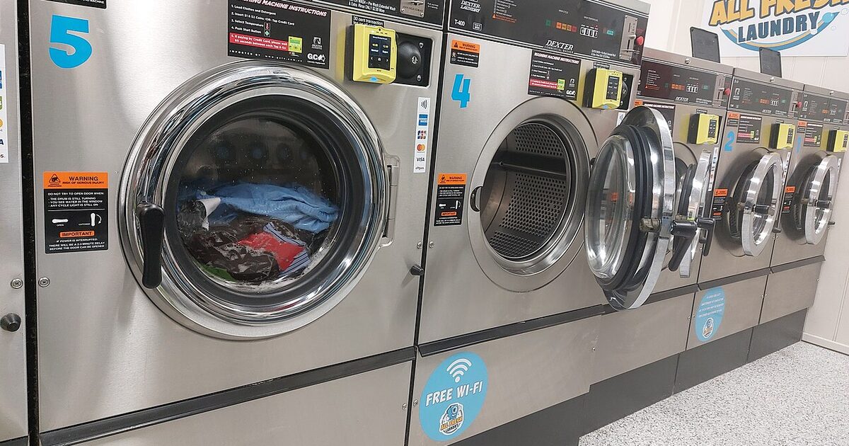 Fila de lavadoras de gran capacidad en una lavandería autoservicio